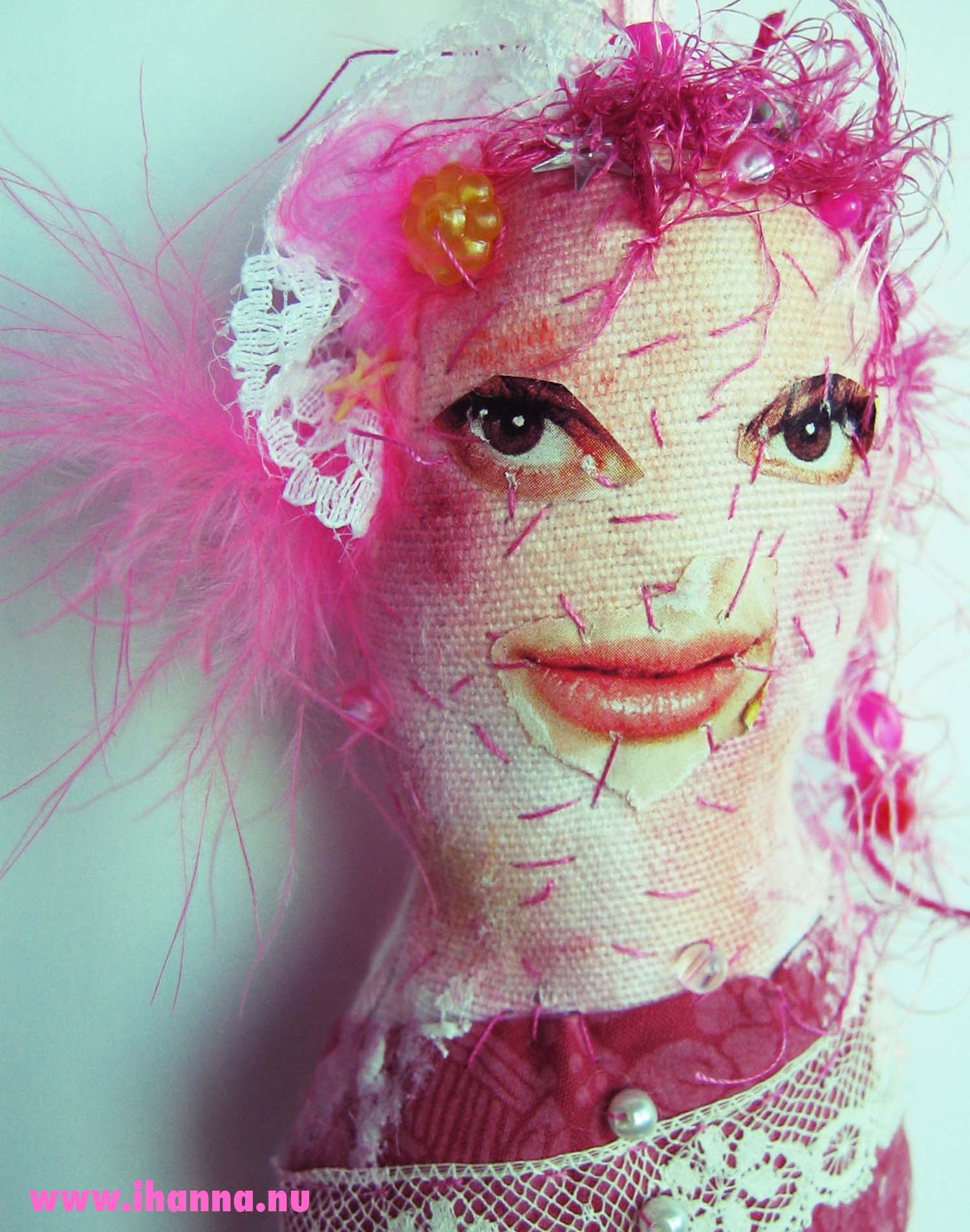 Close up of the face of textile doll Iris, pink art doll