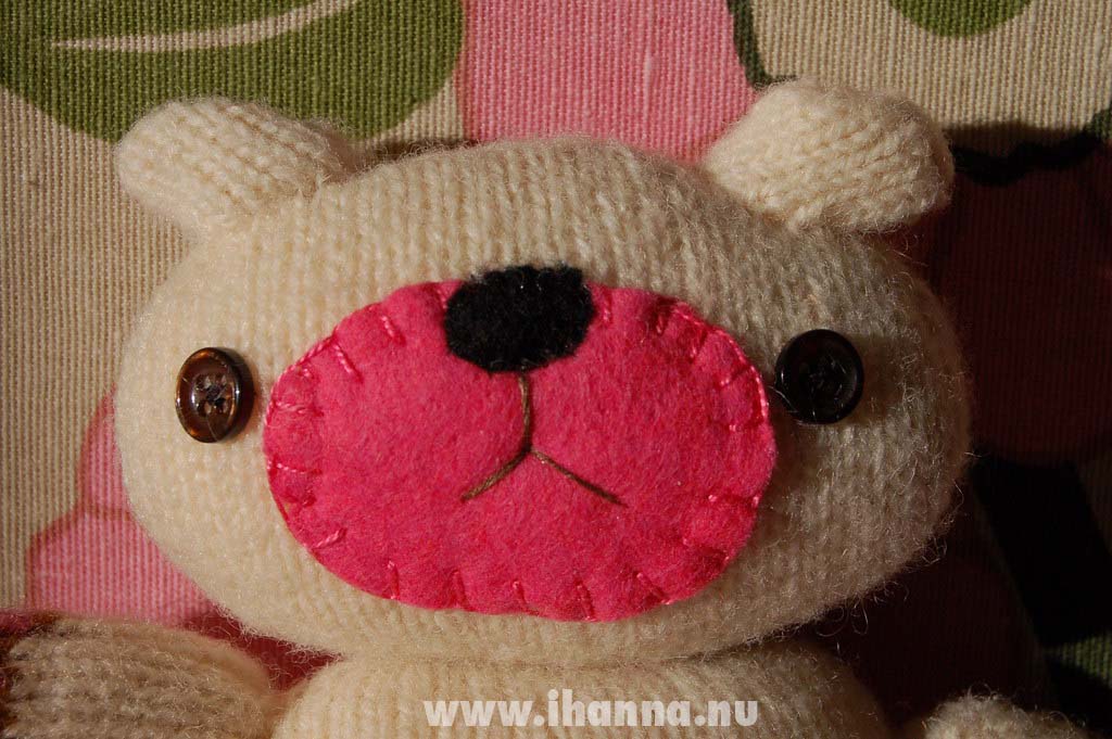 Wool felted sweater made into a teddy bear with button eyes face close up (Copyright Hanna Andersson)