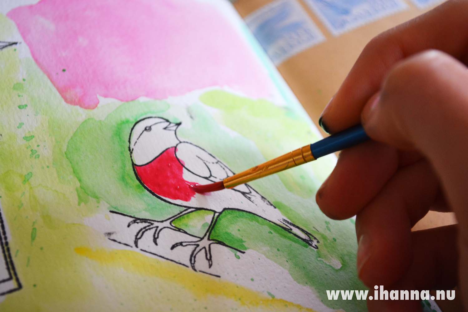 Art Journal Detail: Painting a bird red with watercolors (Copyright Hanna Andersson)