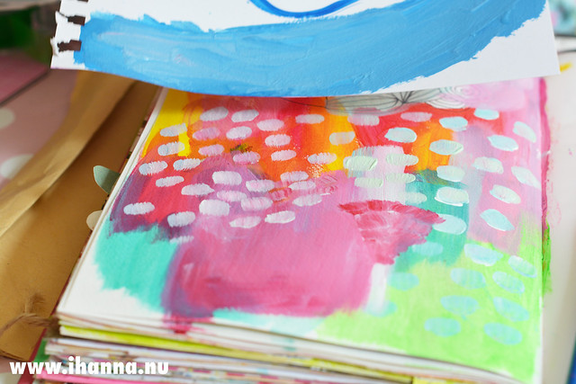 Part of painted art journal spread WIP on the table. Green and pink and yellow background with white dots (Copyright Hanna Andersson)