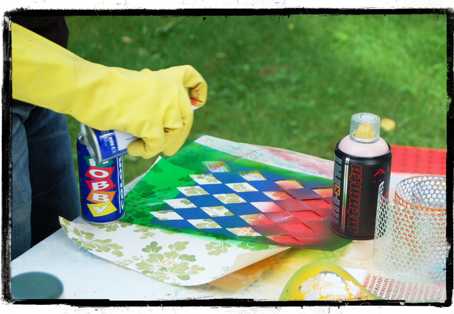 Nina in gloves spraypainting on top of wallpaper pattern (Copyright Hanna Andersson)